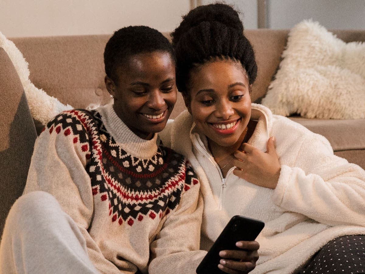 Deux proches regardent ensemble un transfert sur un téléphone.